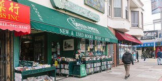 People walking down the street in front of Green Apple Books.