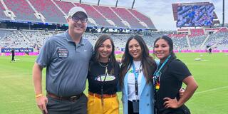 Dave Manning standing with sport management students on a soccer field.