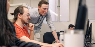 Three students working together on desktop computer