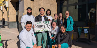 A group of USF students holding a “LA. FIRE DONATE HERE” sign