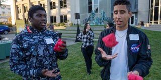 students throw hacky sacks in air