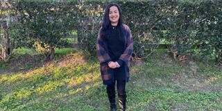 Tonita Barajas MA ‘21 stands on a lawn facing the camera.