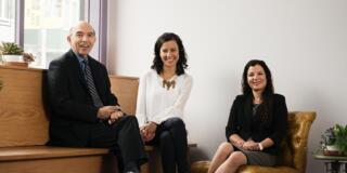 Dr. Sedique Popal, Dr. Didem Ekici, and Malihe Eshghavi sitting and smiling at camera