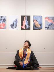 Student sitting on the ground and looking up at posters