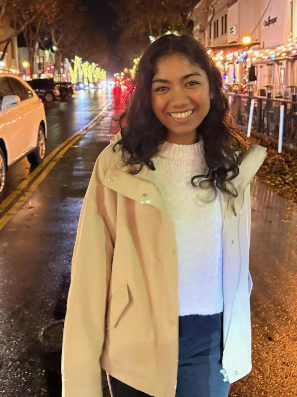 alumna Dhruvika Randad on a street lit sidewalk